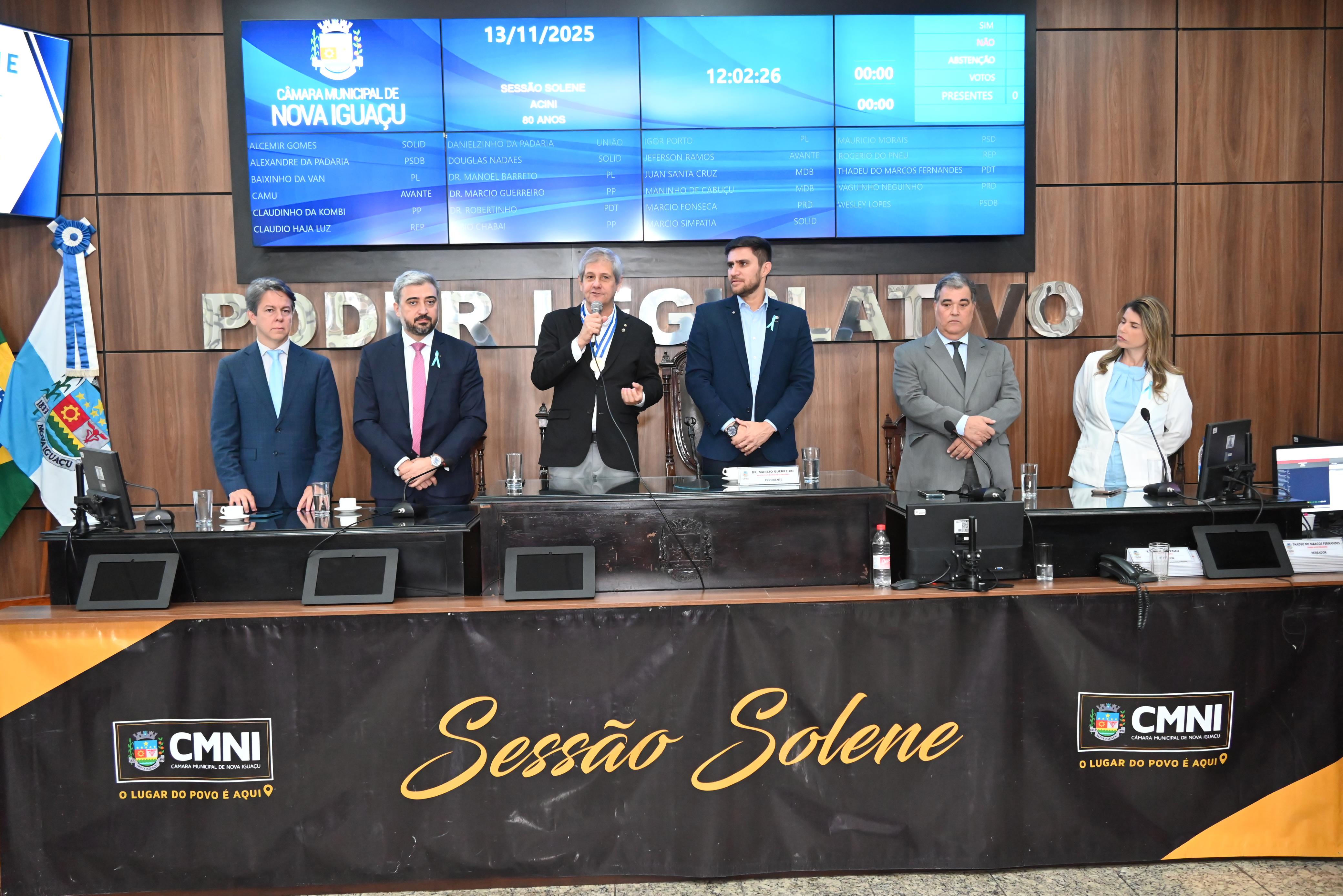 Mesa de honra, a partir da esq: Robson Carneiro, presidente do Conselho SEbraes/RJ; procurador geral de Nova Iguaçu, João Bosco, representando o prefeito Dudu Reina; presidente da ACINI, Mário Lopes; presidente da Câmara, Dr. Marcio Guerreiro; Rui Barreto, presidente do Conselho Superior da ACINI do Rio de Janeiro; e vice-prefeita de  Nova iguaçu, Dra. Roberta 